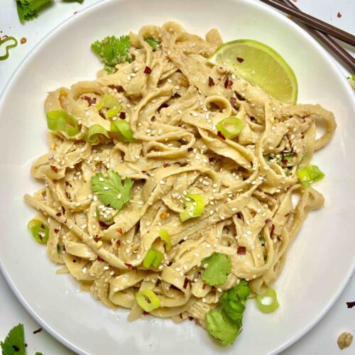 noodles with peanut sauce on plate with chopsticks
