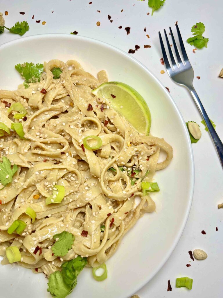 noodles with peanut sauce on plate with fork