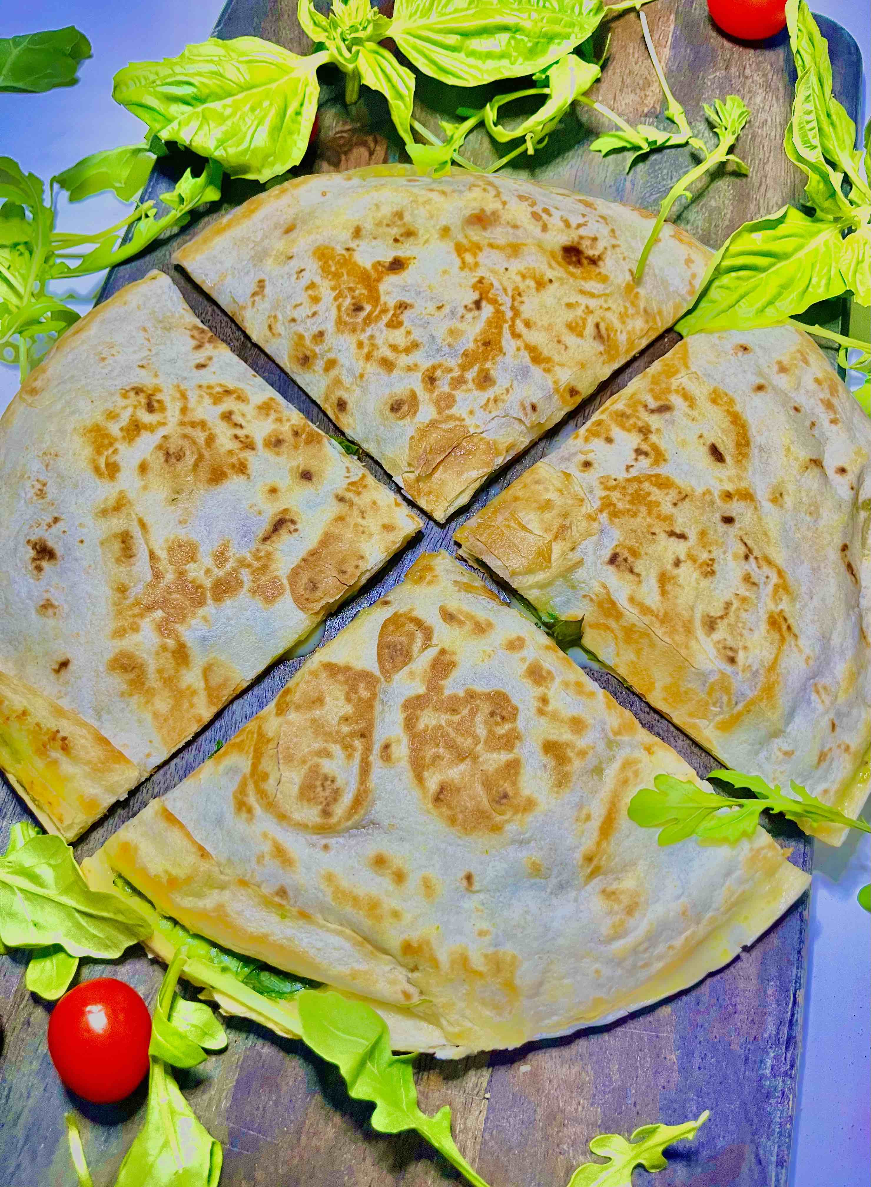 Mediterranean quesadilla sliced into quarters on plate