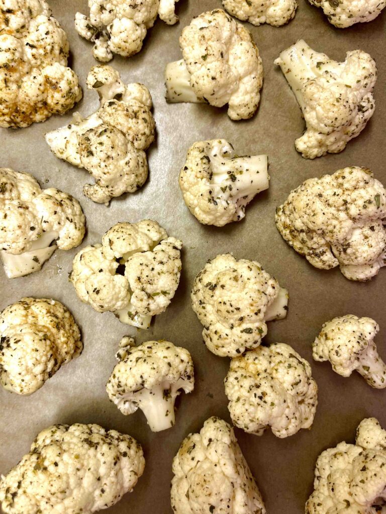 seasoned cauliflower florets on baking pan