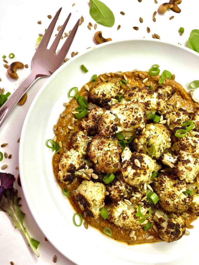 roasted cauliflower in bowl with sauce.