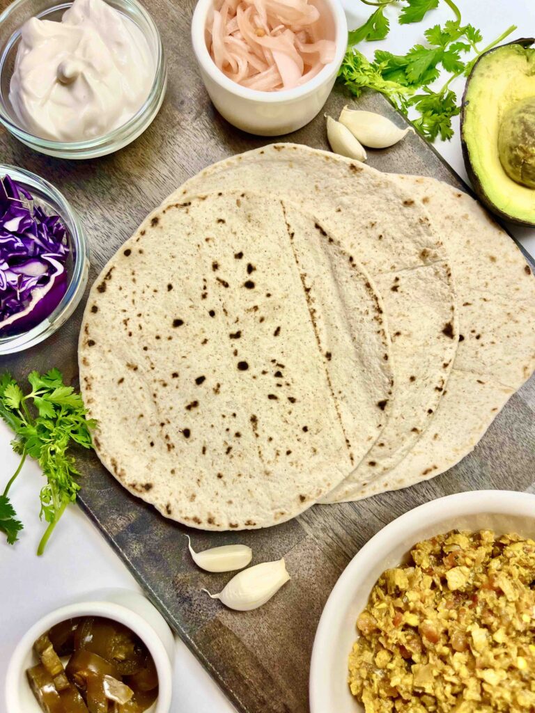 overhead image of tortillas, taco meat, and many possible toppings
