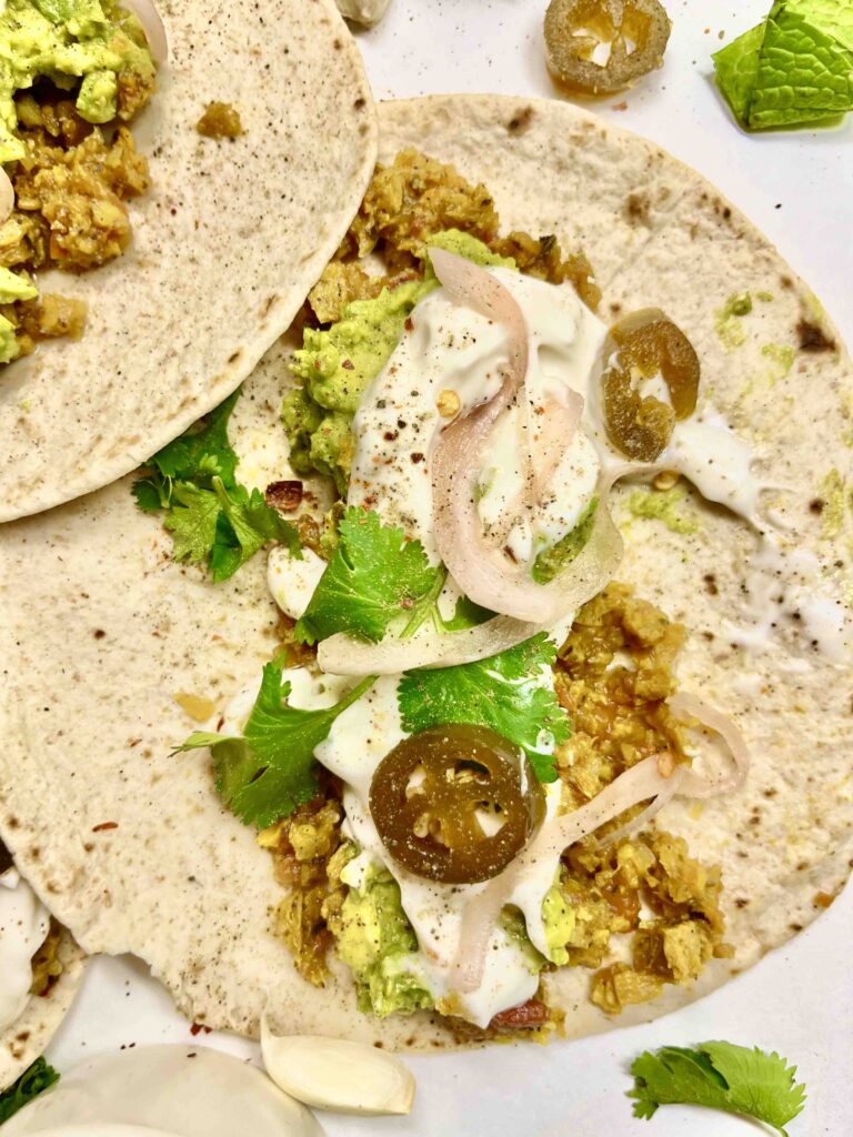 overlapping tortillas with taco meat and garnishes