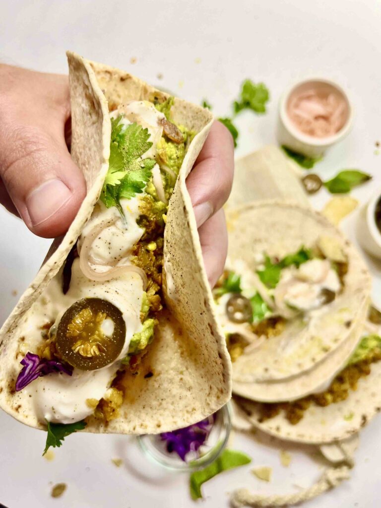 close-up of hand holding soft shell taco