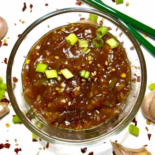 chinese garlic sauce in bowl surrounded by chopsticks and garlic cloves