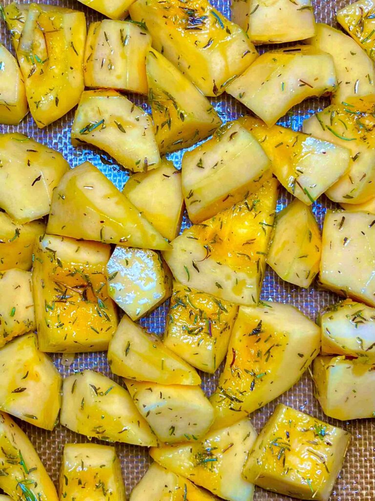 roasted pumpkin cubes with rosemary on pan