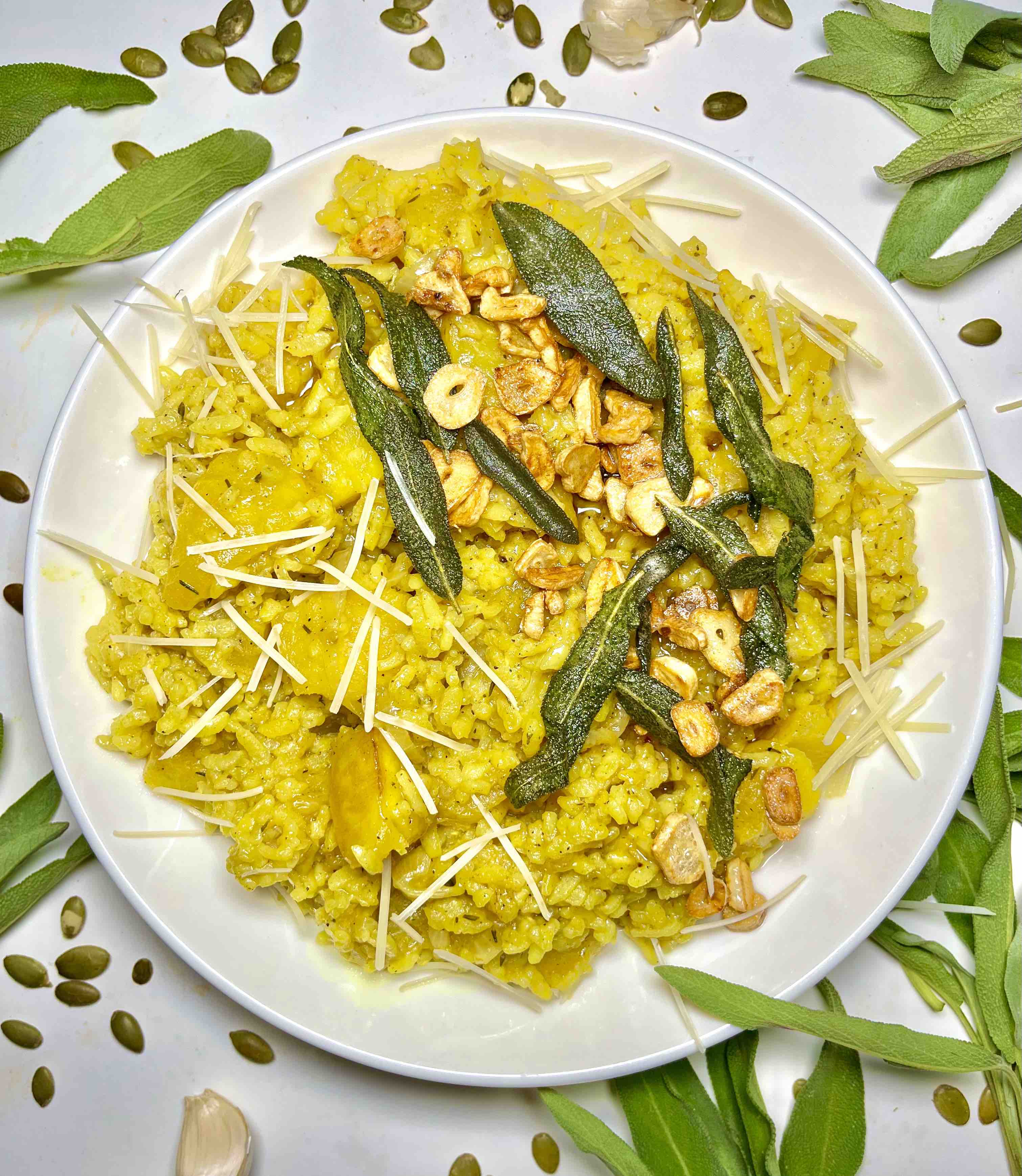 plate of roasted pumpkin sage risotto surrounded by garnishes