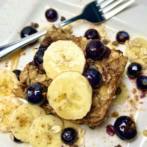 slice of baked oatmeal with fruit garnishes on plate with fork