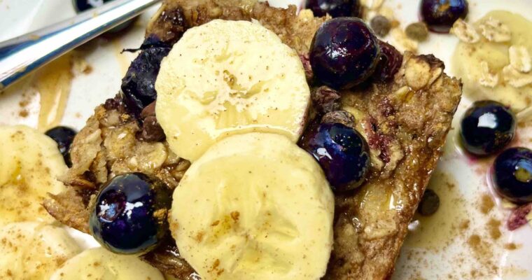 slice of baked oatmeal with fruit garnishes on plate with fork