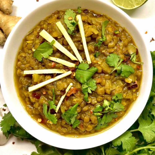 spiced brown lentils in bowl with garnishes