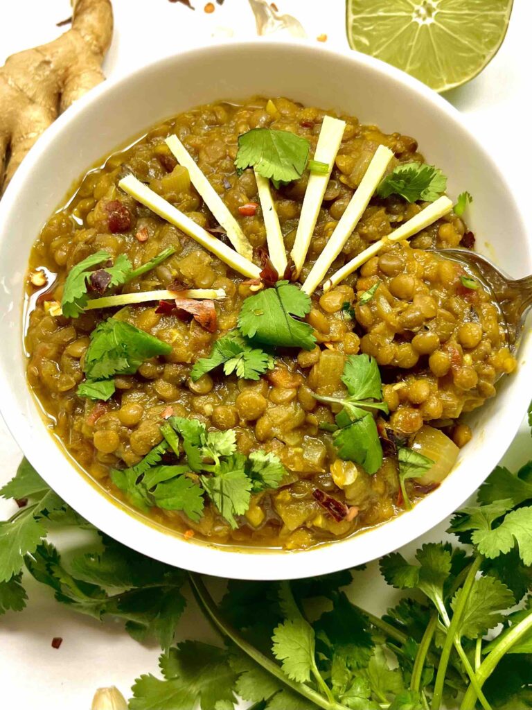 spiced brown lentils in white bowl with spoon