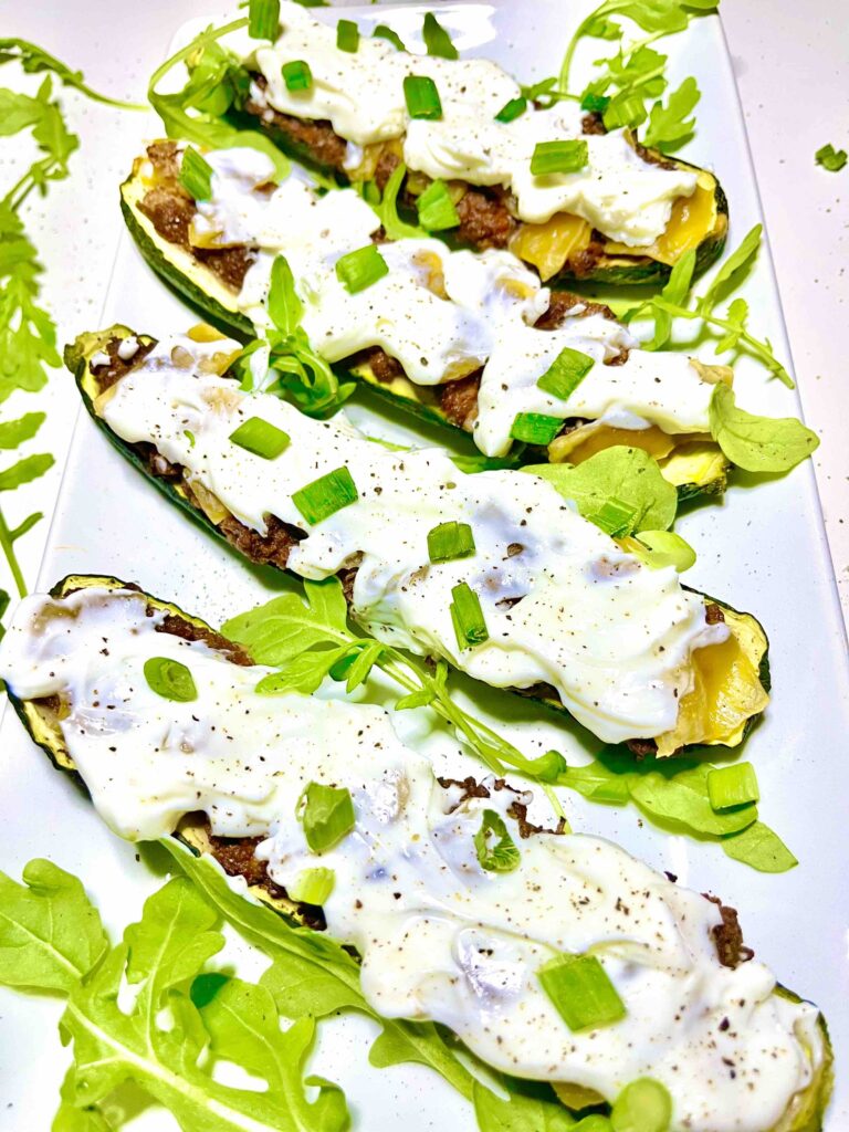stuffed zucchini boats with sour cream and garnishes on plate