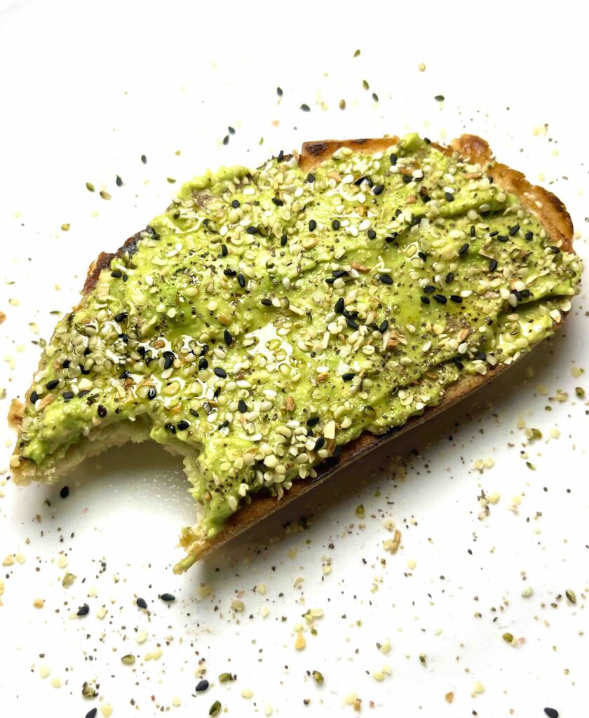 everything avocado toast with a bite taken out