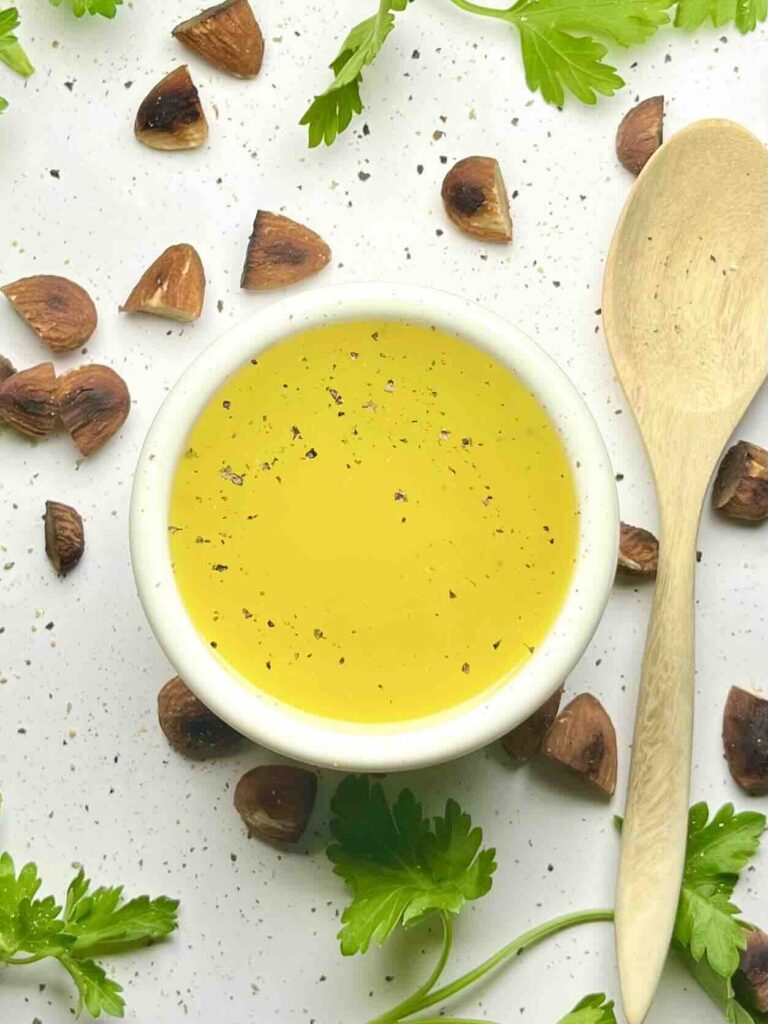 maple dijon vinaigrette in bowl aside wooden spoon seen from above