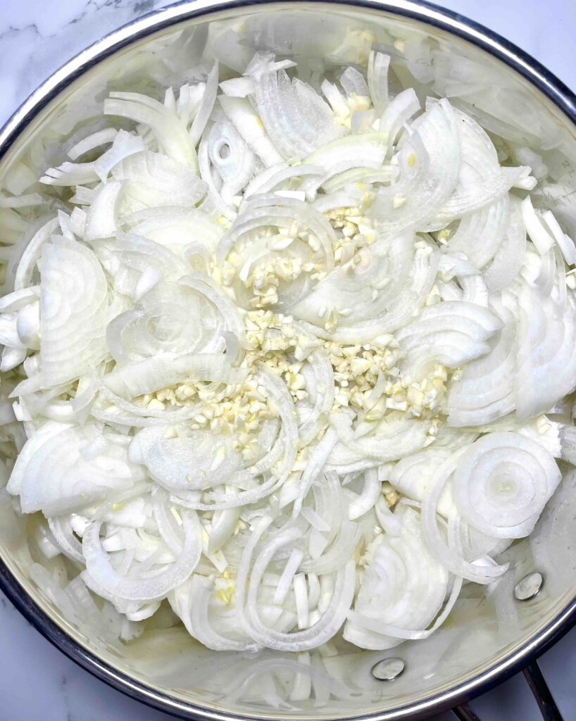 sliced onions and garlic in pan