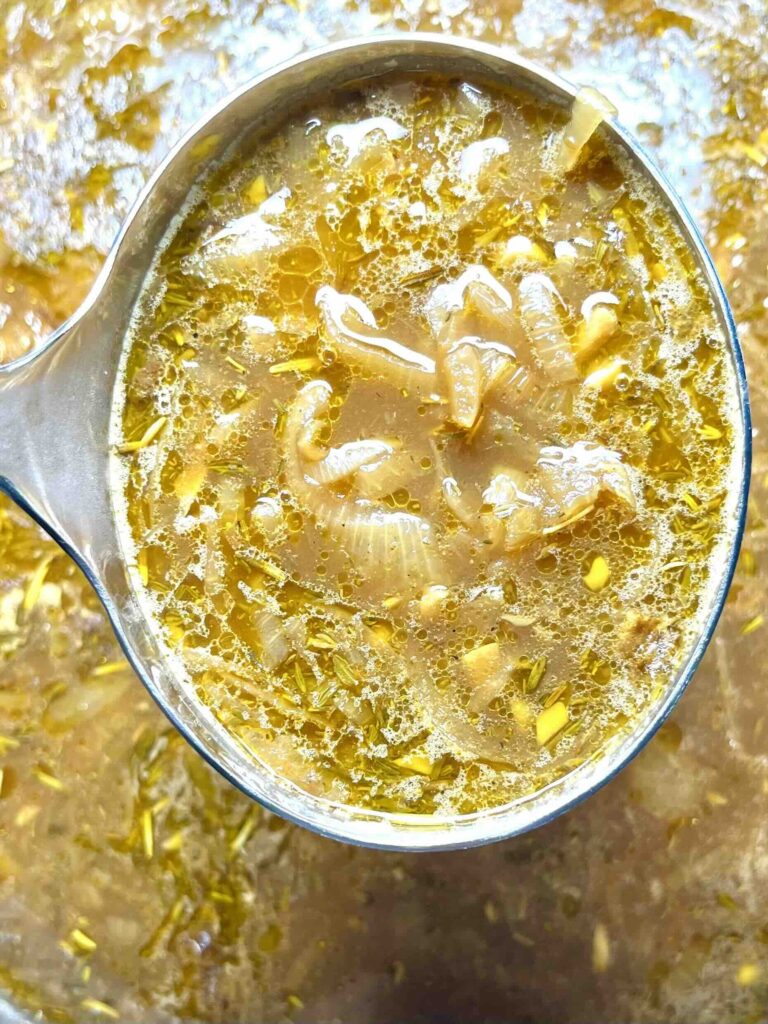 spoonful of french onion soup in close-up