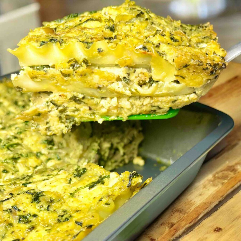 slice of lasagna being lifted out of baking pan