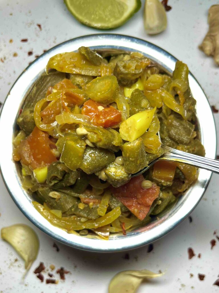 okra masala in serving bowl with close-up of spoonful seen from above