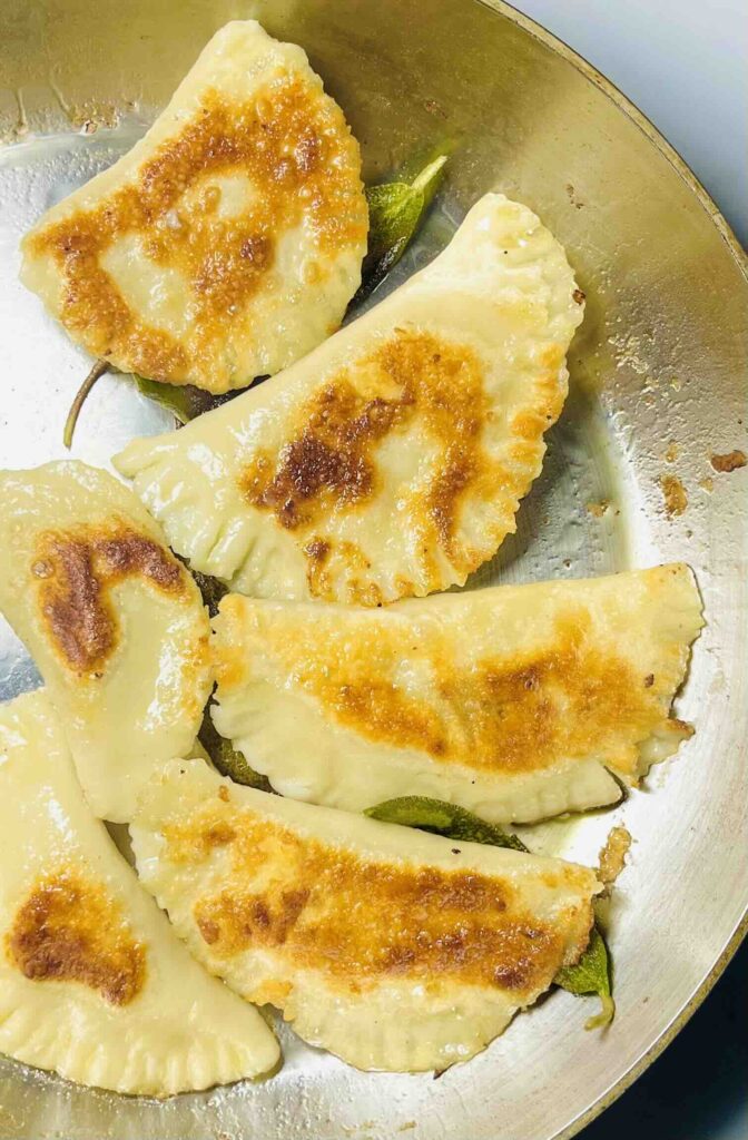 vegan pierogi in a pan being sauteed